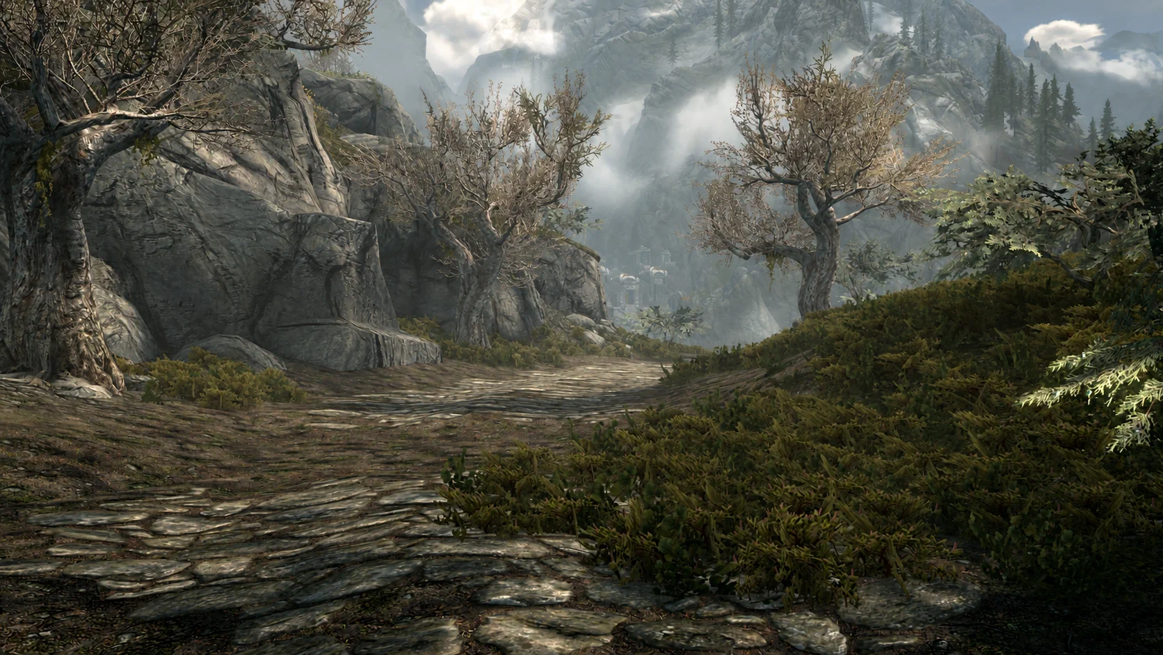 A sunlit road winding through the mountains of the Reach