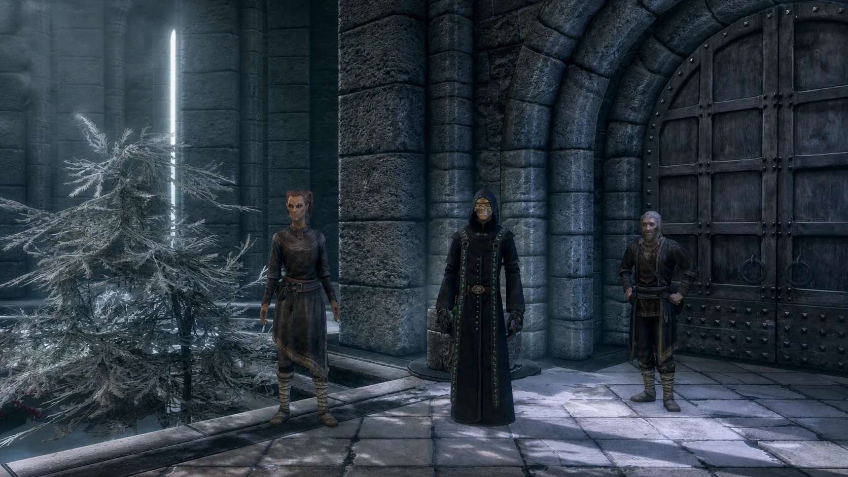 The ascendant masked necromancer standing with College mages in the snowy Winterhold courtyard