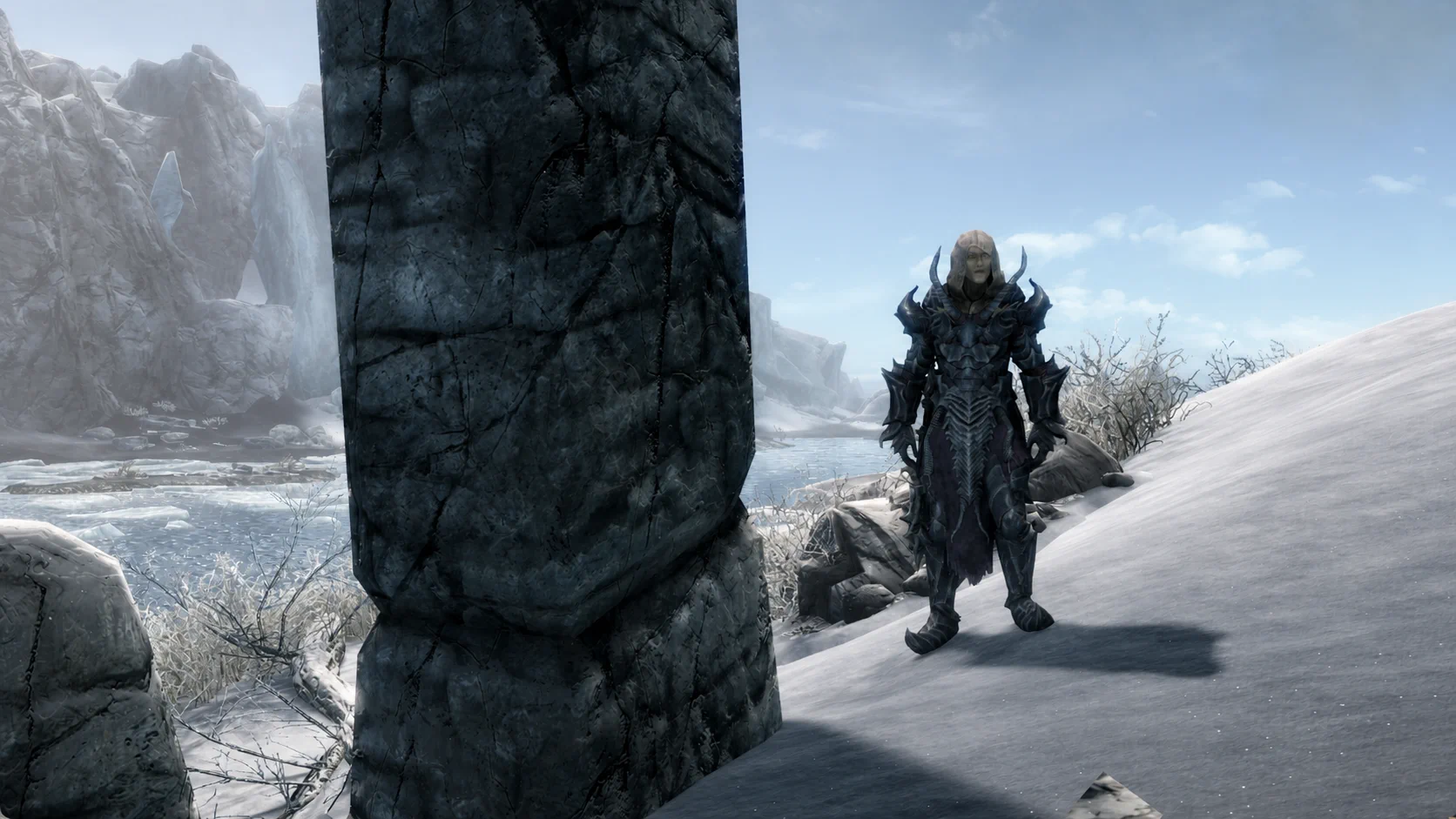 The necromancer wearing a complete dark heavy armor set beside the frozen ruins of Yngol Barrow