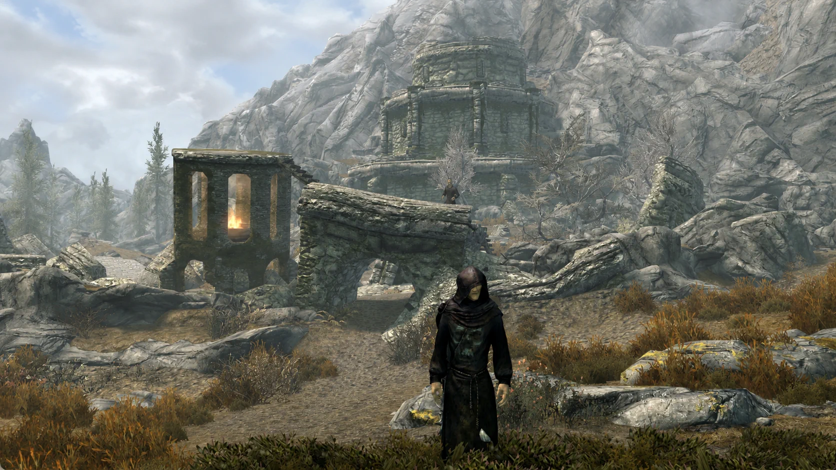 The hooded apprentice standing alone among the broken approaches to Fellglow Keep