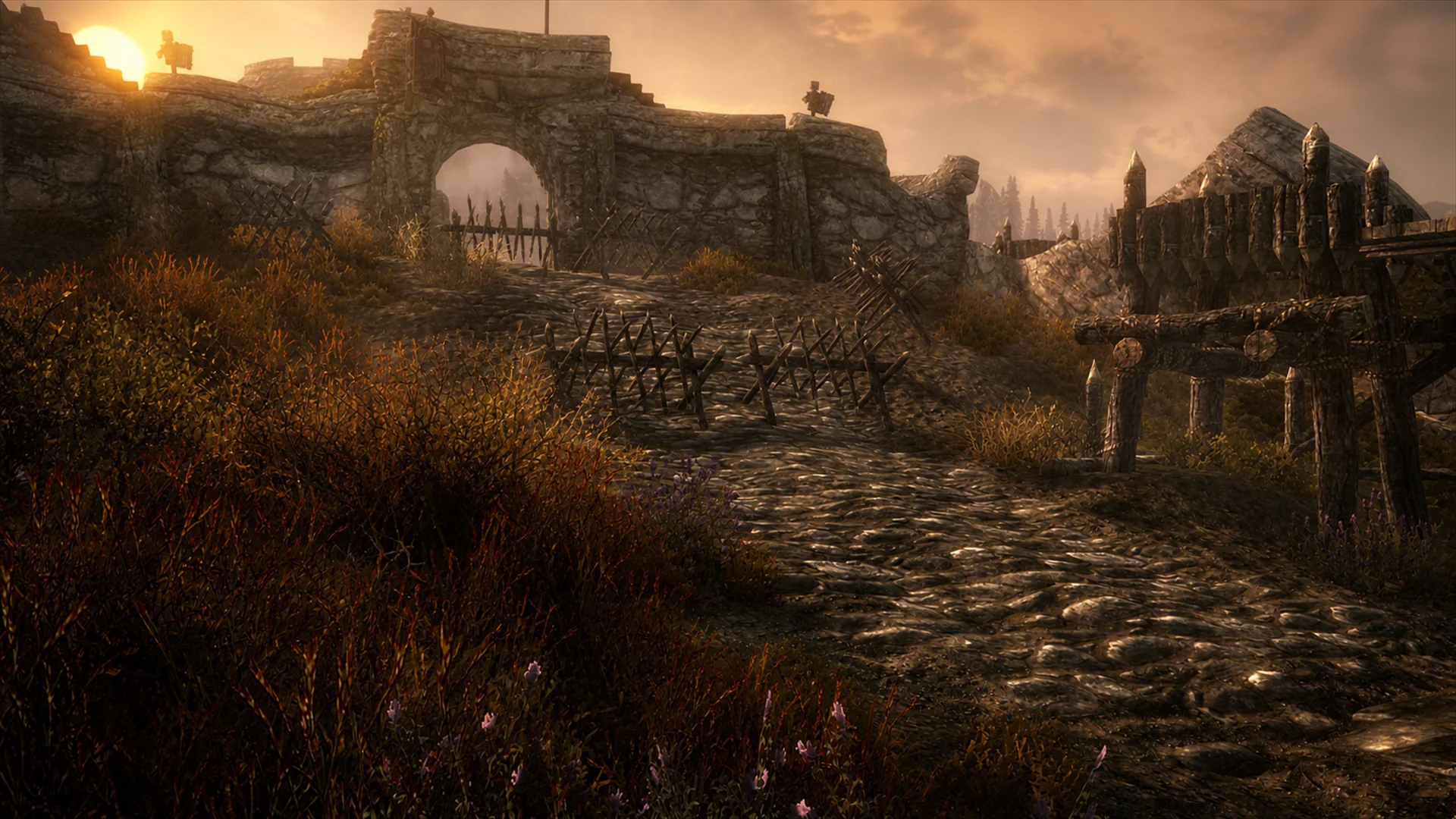 The barricaded road climbing into Fort Greymoor beneath a golden evening sky