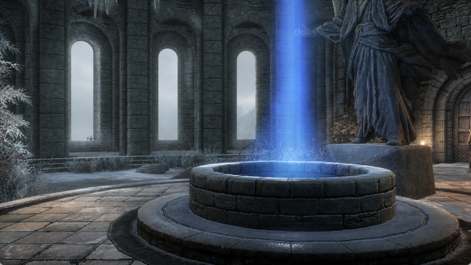 The College of Winterhold courtyard and its blue-lit central well beneath snow and open arches